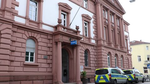 Gebäude der Polizei mit parkenden Polizeiautos davor.