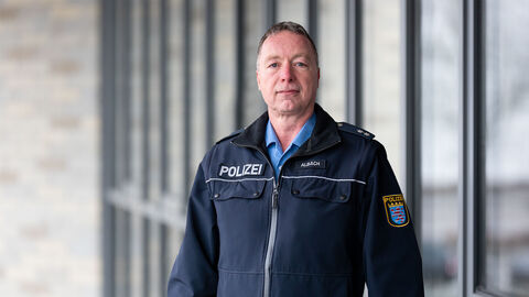 Schutzmann vor Ort Jürgen Albach vor Glaswand 