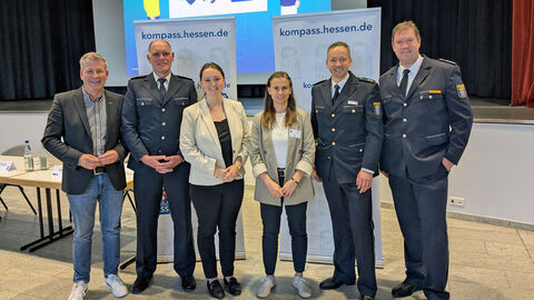 Zweite Sicherheitskonferenz in Hessisch Lichtenau; Foto zeigt die Mitwirkenden v.l.: Dirk Oetzel (Bürgermeister Hessisch Lichtenau), PHK Frank Stöber (Polizei Hessisch Lichtenau), Juliane Eichenberg (Stadt Hessisch Lichtenau), Julia Lohse (PP Nordhessen - Sachgebiet Prävention), POR Christopher Pfaff (Leiter Polizeidirektion Werra-Meißner) und PHK Alexander Först (Polizeidirektion Werra-Meißner) nebeneinanderstehend vor dem Podium des Veranstaltungsraumes, im Hintergrund eine Präsentationswand