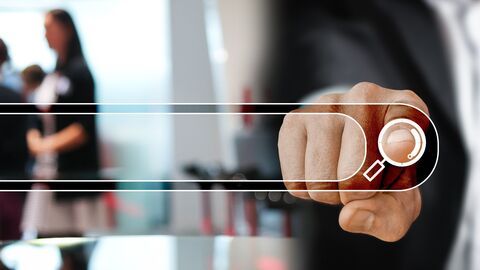 Suchschlitz, im Hintergrund verschwommenen Personen, Zeigefinger zeigt auf Suchschlitz als Aufforderung