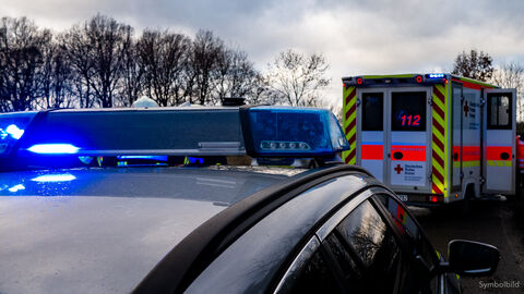 Symbolbild - Unfallflucht; Blaulicht eines Streifenwagens im Hintergrund ein Rettungswagen