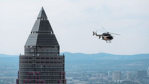 Frankfurter Messeturm mit Polizeihubschrauber in Frankfurt am Main