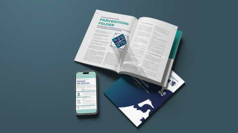 Broschüre Jahresbericht Prävention und Smartphone mit einer Teilansicht des Berichts werden dargestellt