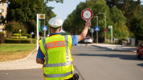 Blitz für Kids in Nordhessen; Foto zeigt einen Polizeibeamten mit Anhaltekelle auf einer Fahrbahn